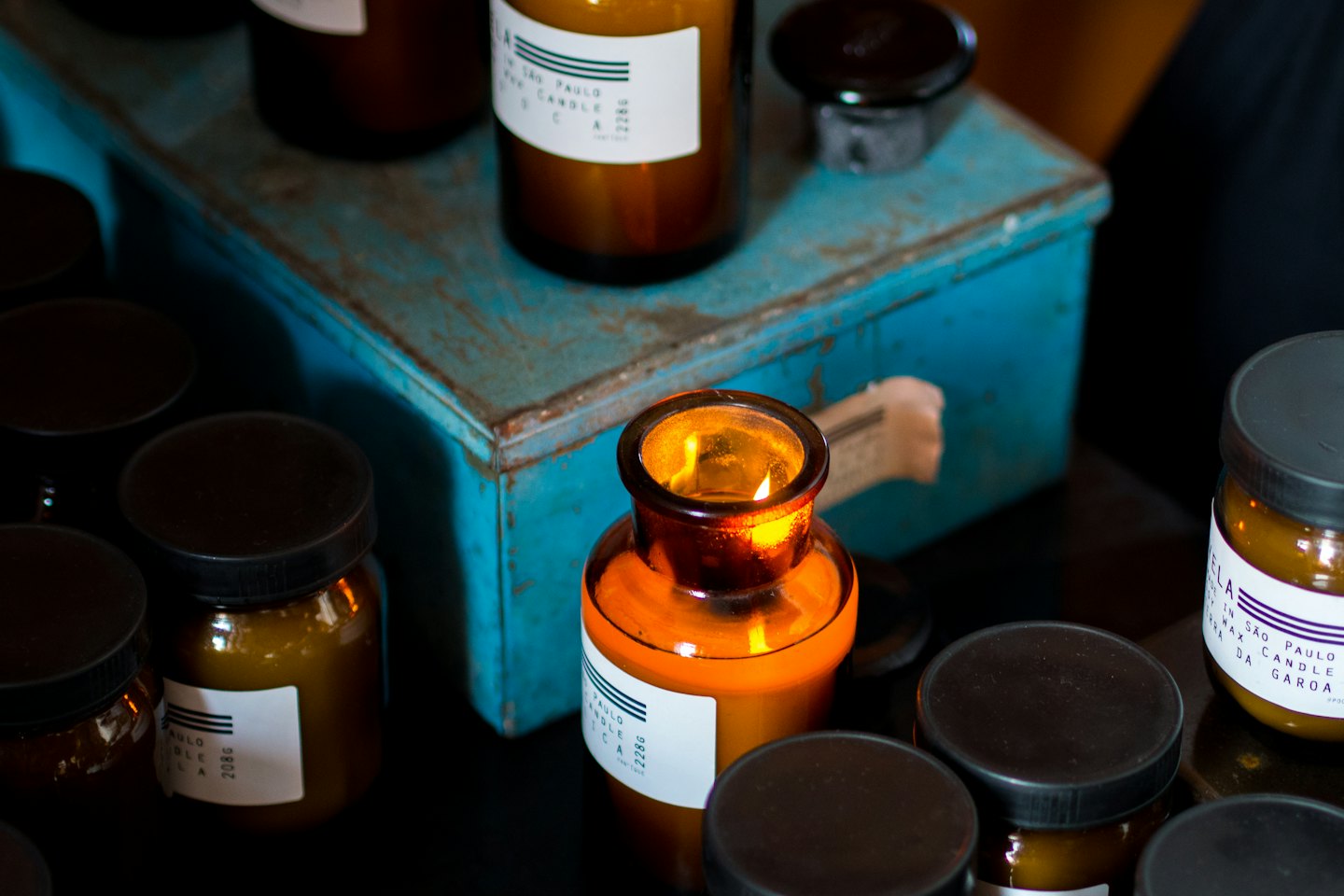 Amber glass jars and bottles with lids and flickering flames.